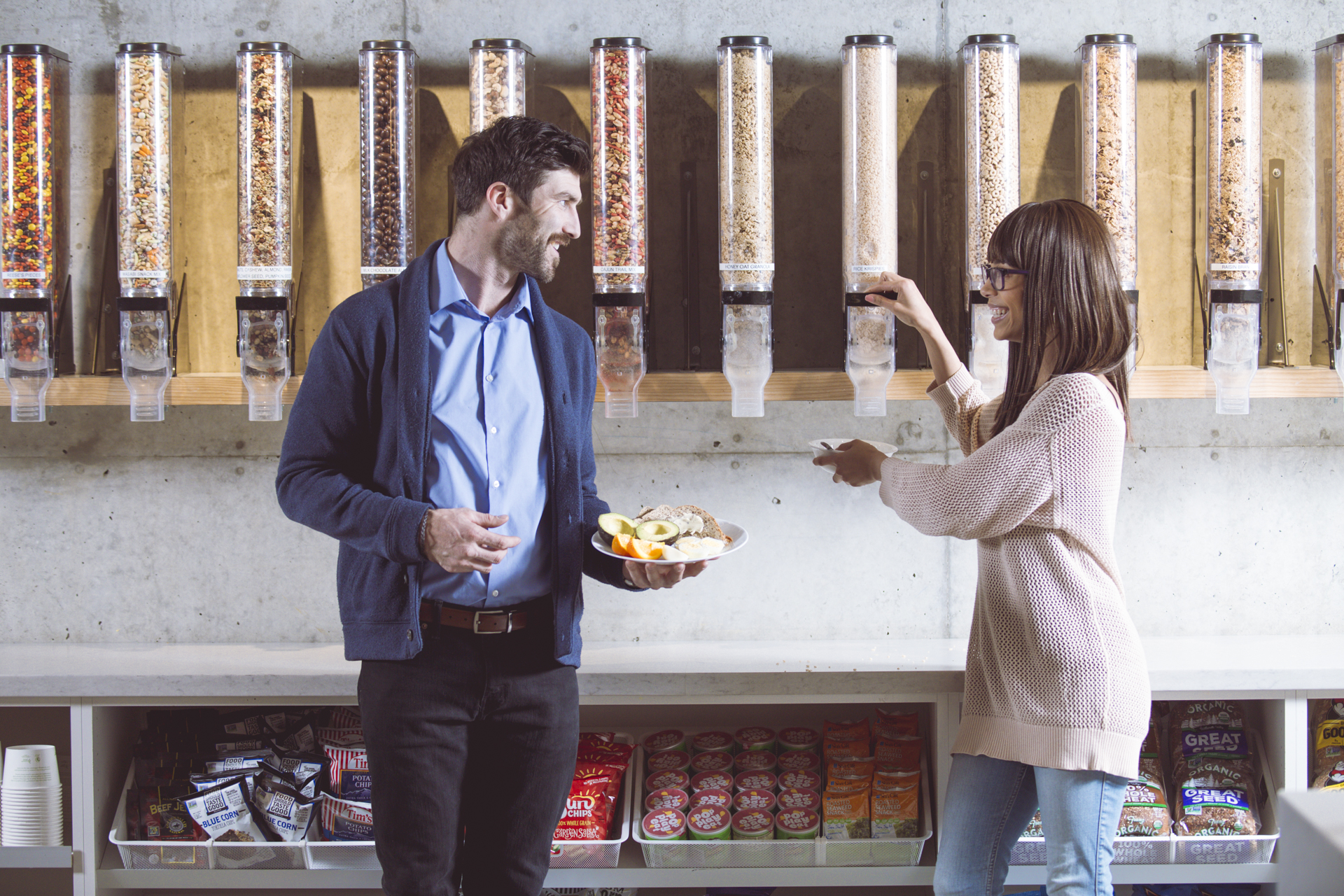 Workers in a breakroom pantry getting snacks and food