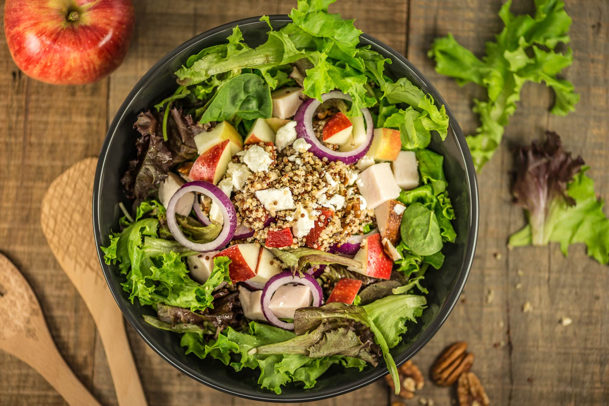 Strawberry, nut, onion, and cheese salad, wooden spoons, salad in bowl