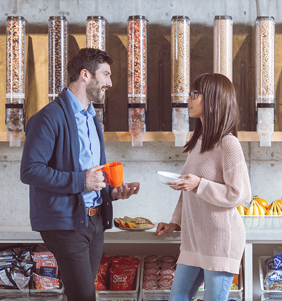 People laughing over coffee and breakfast in a canteen breakroom