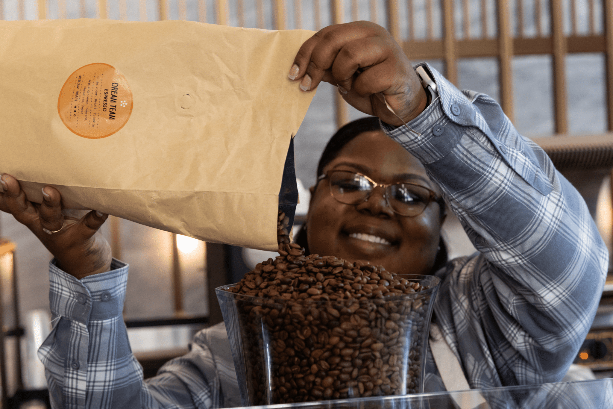 Tradecraft Barista pouring coffee beans into a hopper