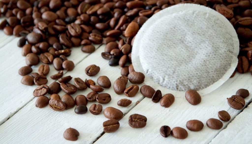 Coffee pods with coffee beans on the background