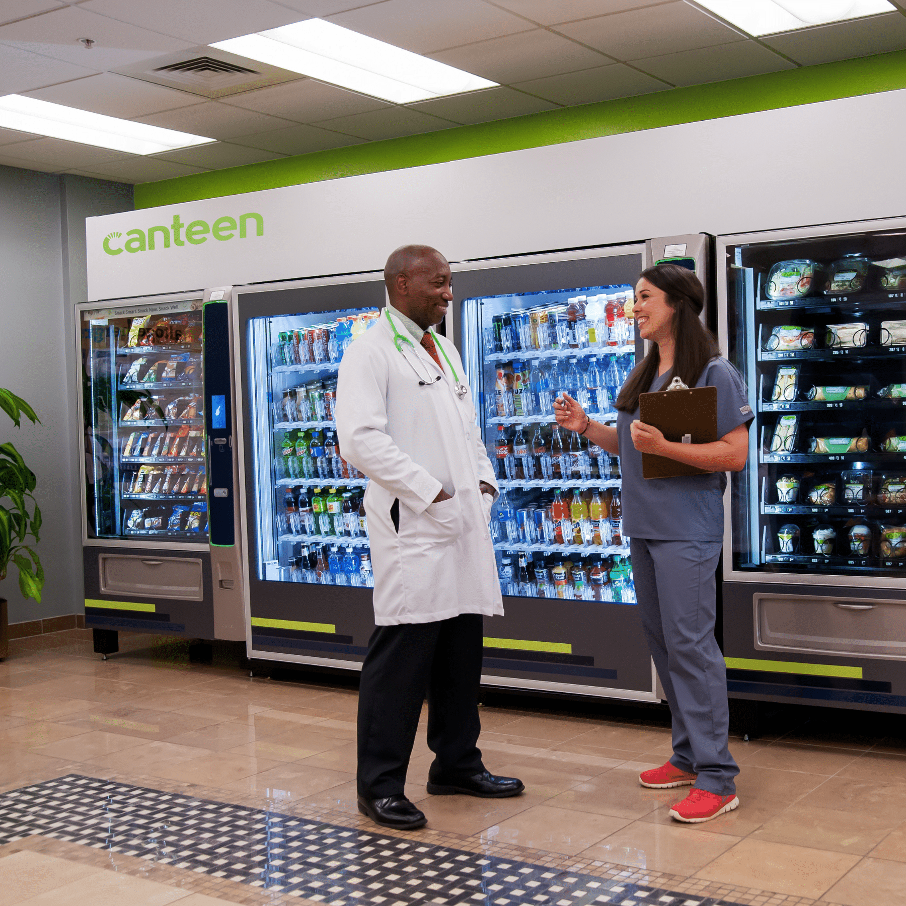 Doctor and nurse speaking in front of vending in breakroom