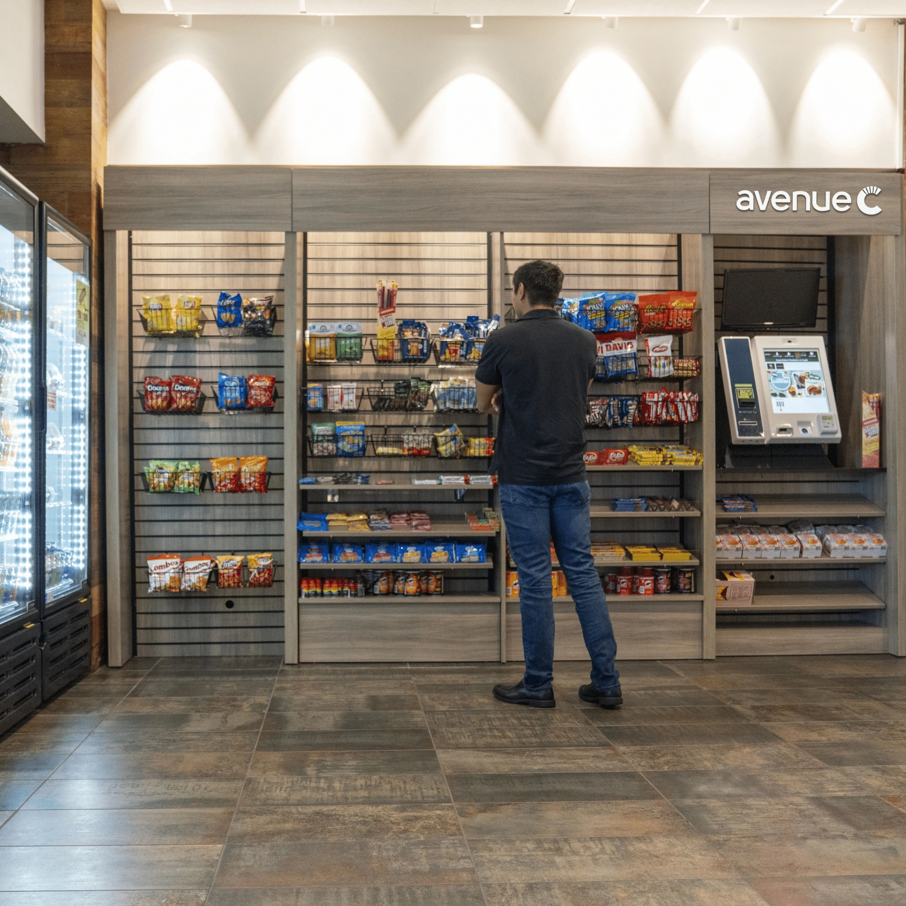 Man standing at an avenue c market and looking at snacks