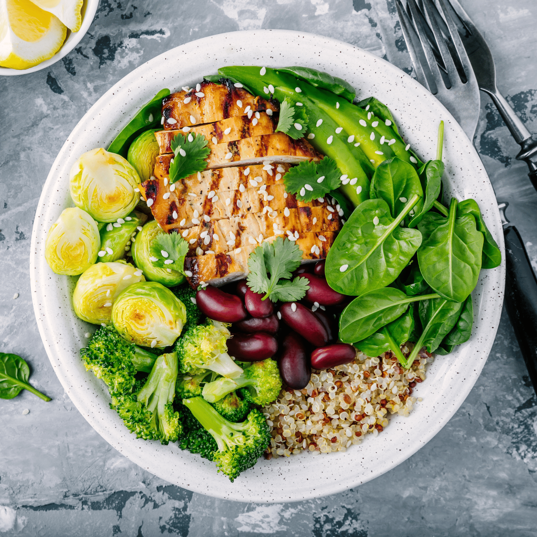 Chicken, avocado, quinoa, broccoli, spinach, beans, and brussel sprout bowl