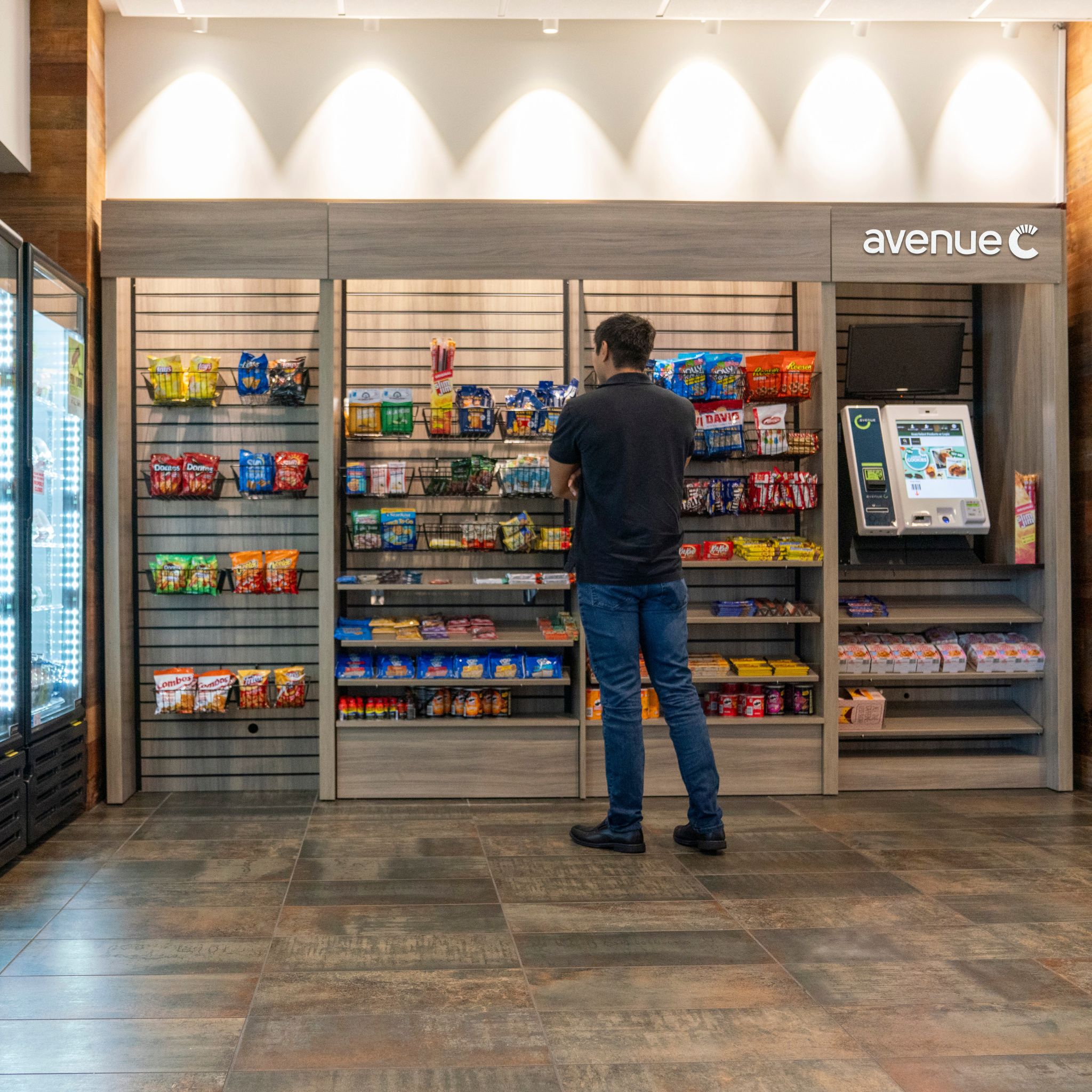 Man Contemplating at an Avenue C Man deciding on a snack at a micro market, Canteen Avenue C, variety of snacking and drink options