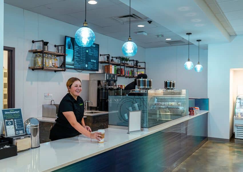 Student barista serving coffee, student café, barista smiling with coffee, education setting