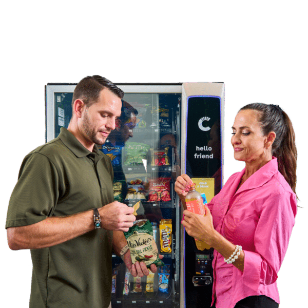 Two people eating snacks in front of a Canteen vending machine, snack and drink vending, vending options