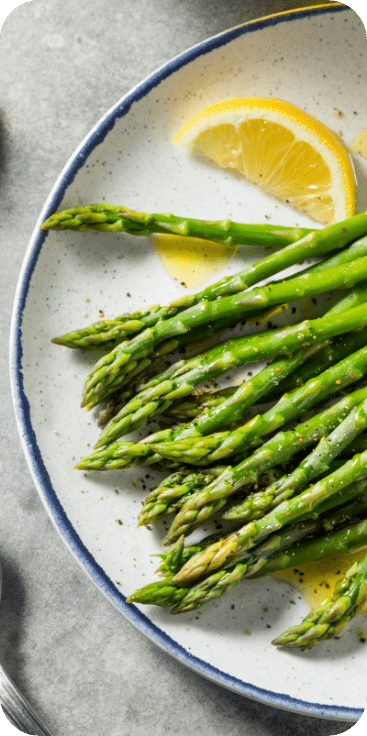 Asparagus on a plate with a lemon slice - Chef's Table