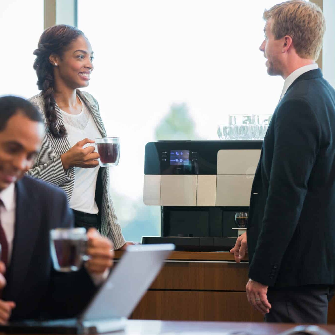 Finance workers talking with coffee, self-service coffee machine, office coffee equipment