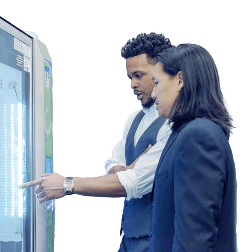 Two People Using Vending Machine Two men looking at a vending machine and pointing to an option