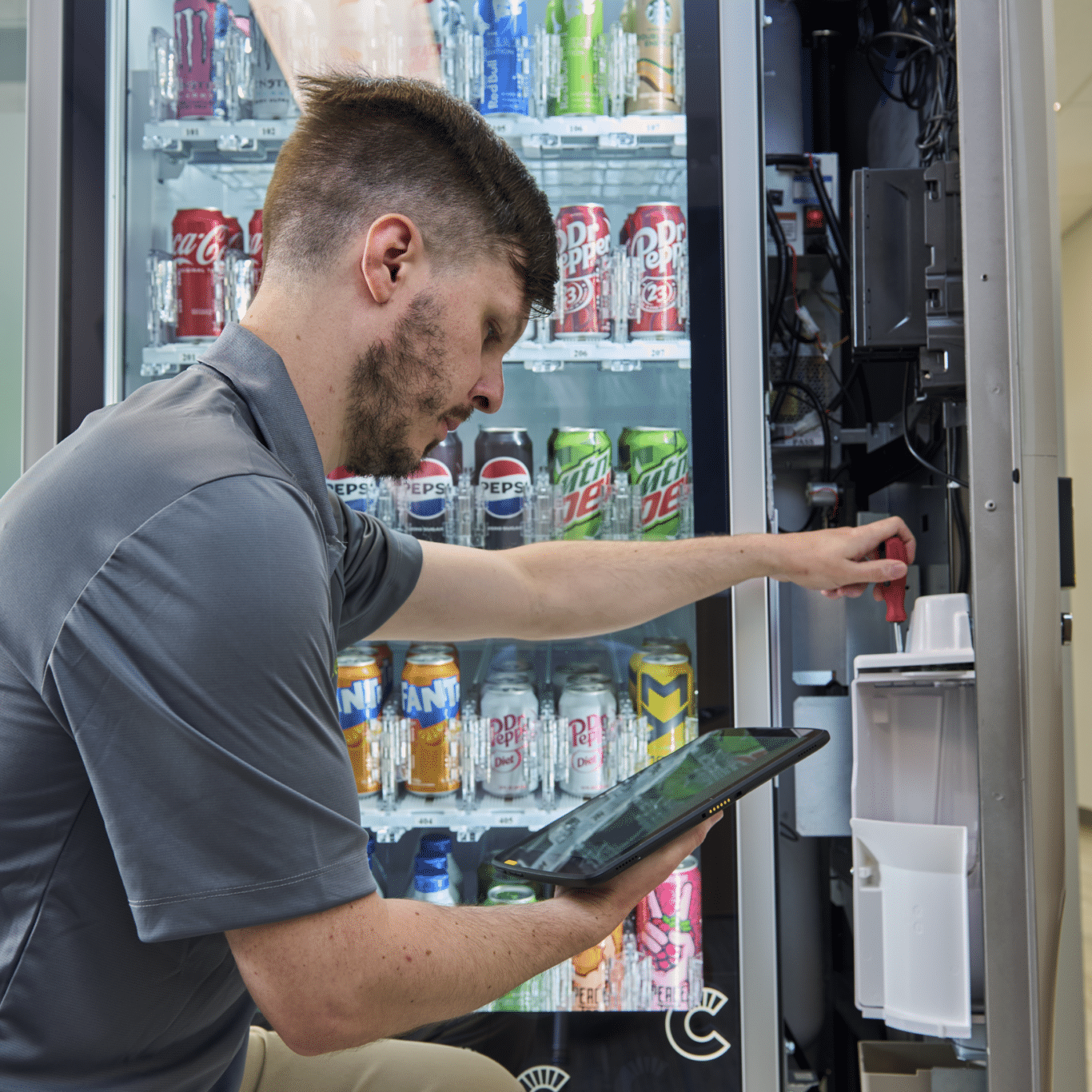 Canteen Employee Vending Maintenance Canteen employee fixing a vending machine, vending technology maintenance, reliable vending service