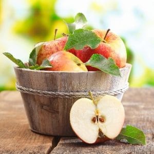 A wooden bucket with apples on it