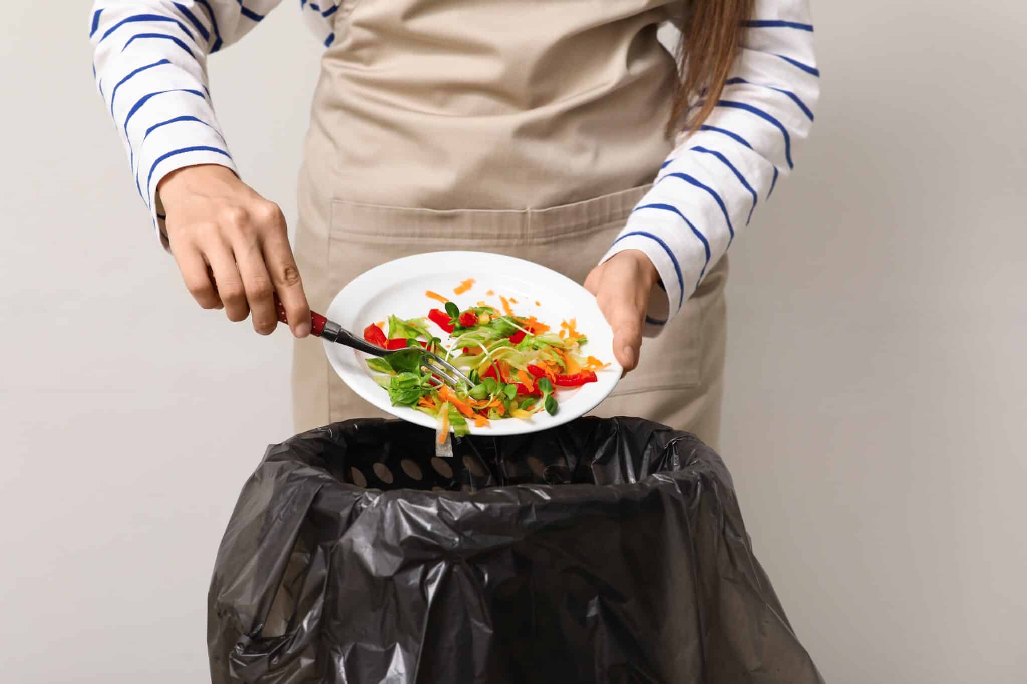 Woman throwing away salad